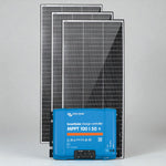 Three Exotronic 220W solar panels standing behind a blue Victron SmartSolar MPPT 100/50 charge controller