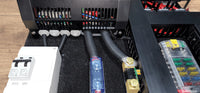 Detail view of the white AC consumer unit and cable routing at the bottom of the board