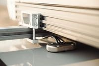 Close-up of the aluminium multi cable seal installed on a grey surface