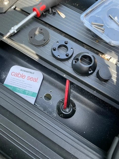 Cable seal parts laid out on a textured black surface during installation