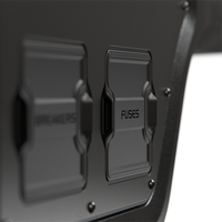 Close-up of protective black covers labelled Breakers and Fuses on the canopy power system