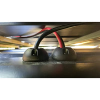 Two black vertical cable seals installed side-by-side routing cables into a flat surface