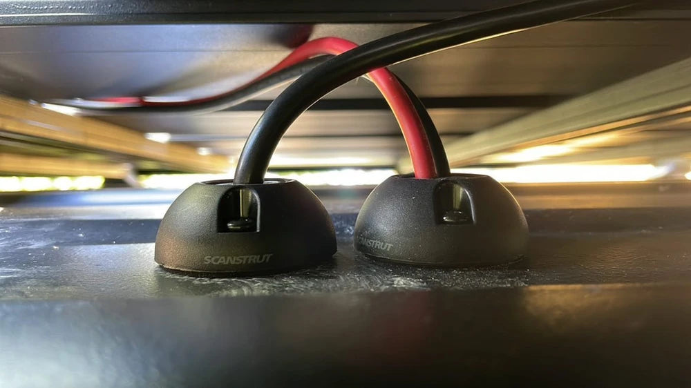 Side view of two installed cable seals with red and black cables