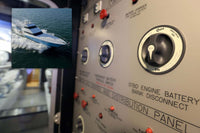 Blue Sea battery switch mounted on a boat control panel with inset yacht photo