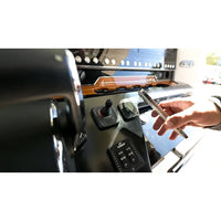 Marine wireless charger installed on a boat dashboard next to helm controls
