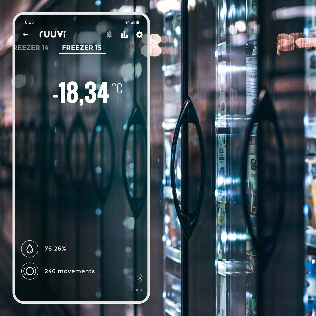 Smartphone displaying Ruuvi app dashboard with temperature reading of minus 18 degrees in front of commercial freezer