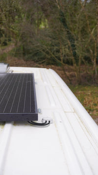 Close-up of Scanstrut cable seal on a white vehicle roof routing two black wires