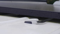 Low profile grey cable seal installed on a textured white roof surface