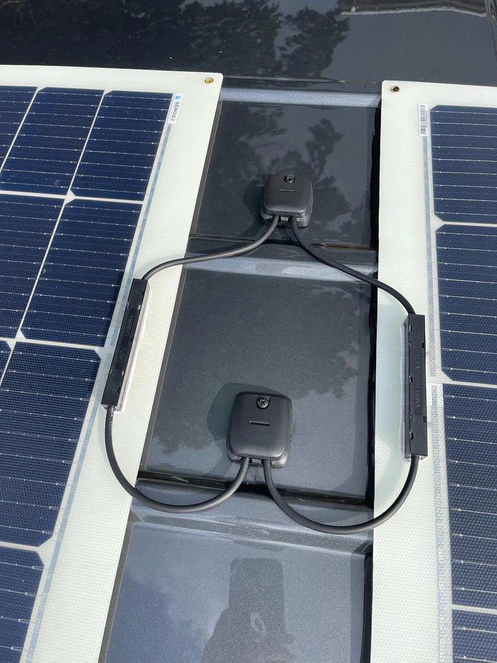 Top-down view of dual solar cable seal installation on a dark roof