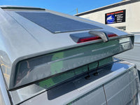 Two cable seals mounted on a grey van roof near a solar panel
