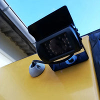 Grey cable seal used for reverse camera wiring on a yellow vehicle exterior