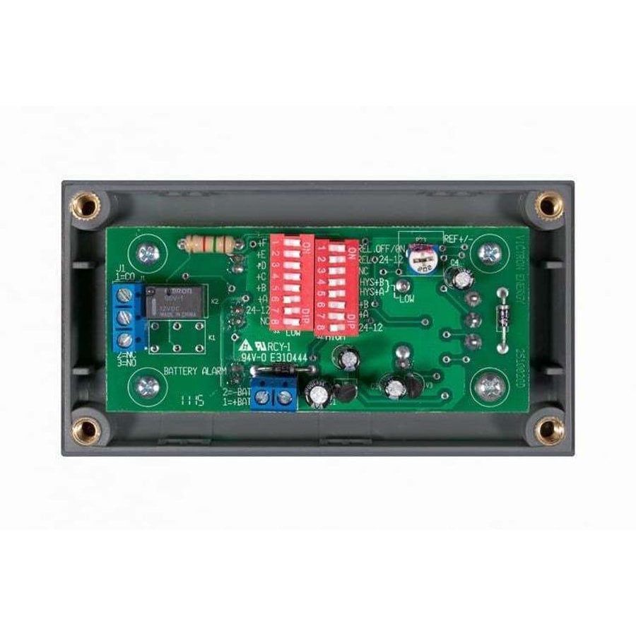 Internal view of battery alarm showing PCB with DIP switches and terminal blocks