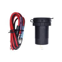 Socket with closed protective cap lying next to the coiled red and black wiring harness