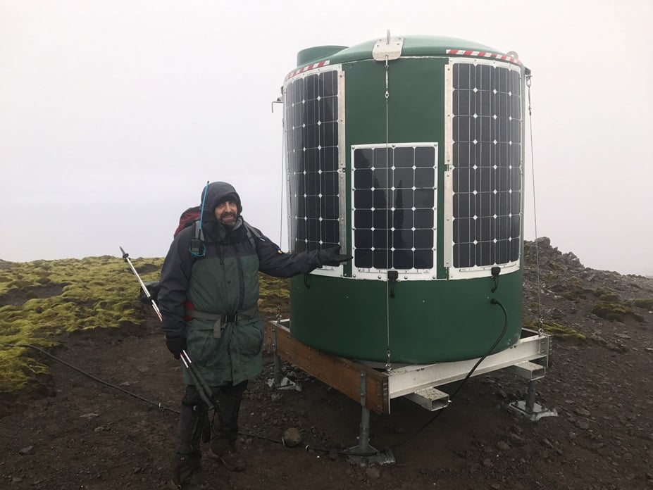 Aust Antarctic Divs Tom Luttrell beside repeater station with flexible solar panels