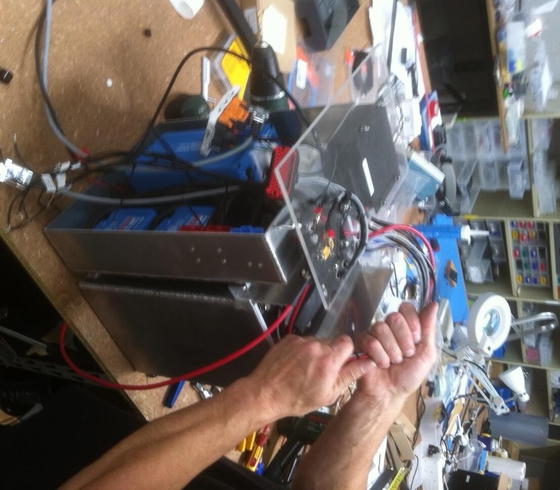 Lithium batteries and inverter being assembled for school in a box PNG