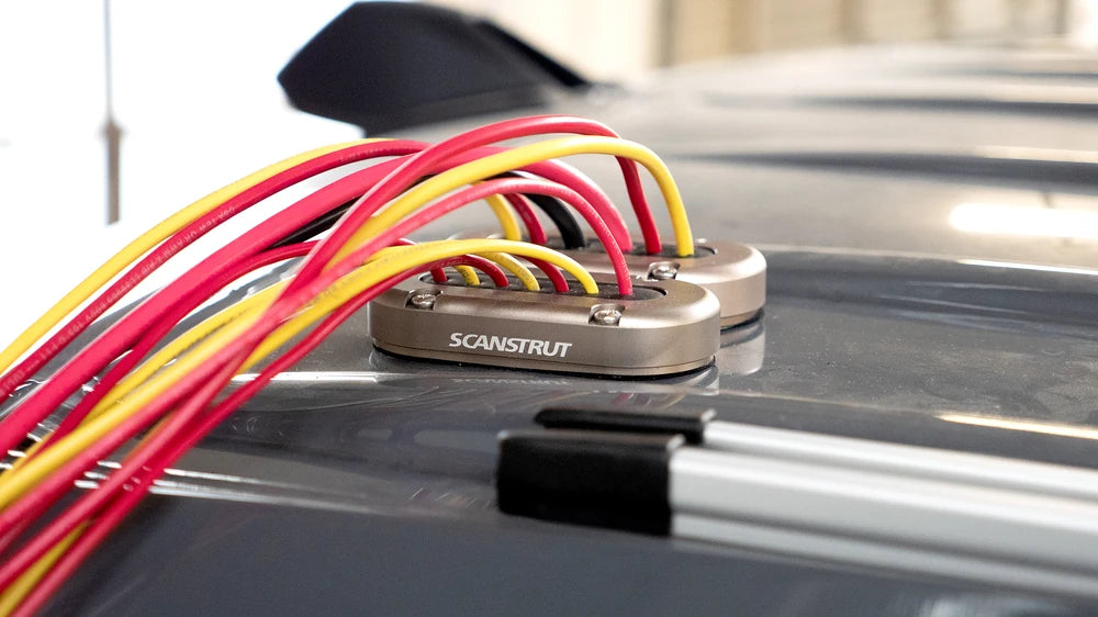 Two aluminium cable seals installed on a vehicle roof managing multiple wires