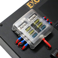 Close-up of 6-way fused busbar with 15A and 20A fuses under clear cover