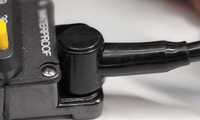 Close-up of black insulating boot installed on a circuit breaker terminal connection