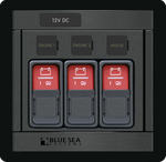 Blue Sea Panel 360 control lockout slides protecting three ML-Series switches on a marine electrical panel