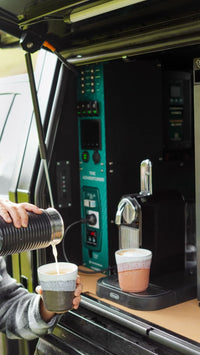 Person pouring coffee next to a canopy power system installed in a 4WD vehicle