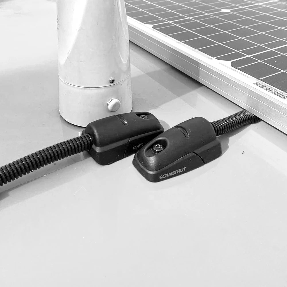 Two black cable seals routing conduit into a white vehicle roof next to a solar panel