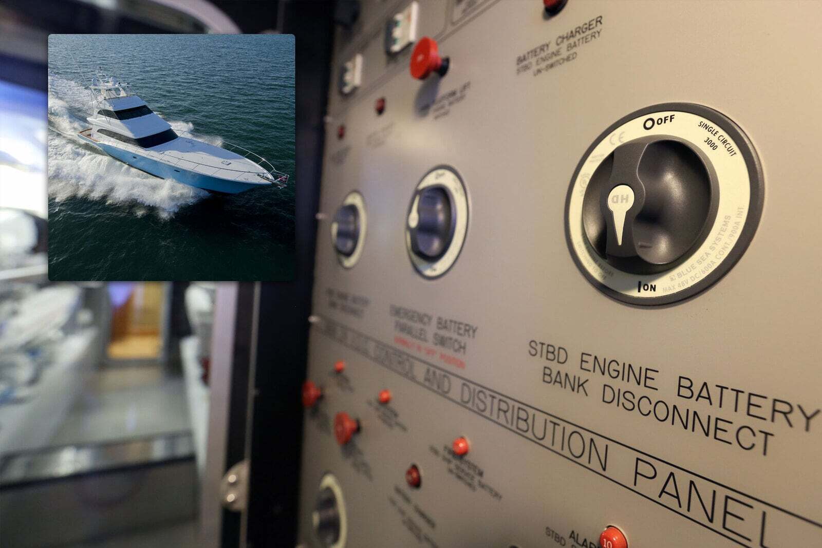 Blue Sea battery switch mounted on a boat control panel with inset yacht photo