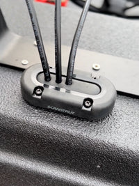 Three black cables entering a vertical Scanstrut seal on a textured black surface