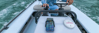 Lifestyle view of a smartphone charging in a marine-grade mount on a boat console