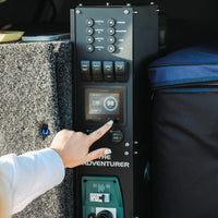 Hand operating the Simarine touch screen battery monitor on an Adventurer power system