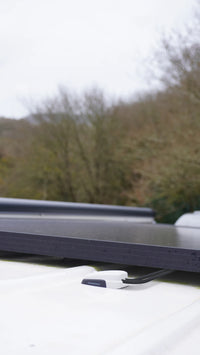 Grey Scanstrut cable seal mounted on a white van roof next to a solar panel