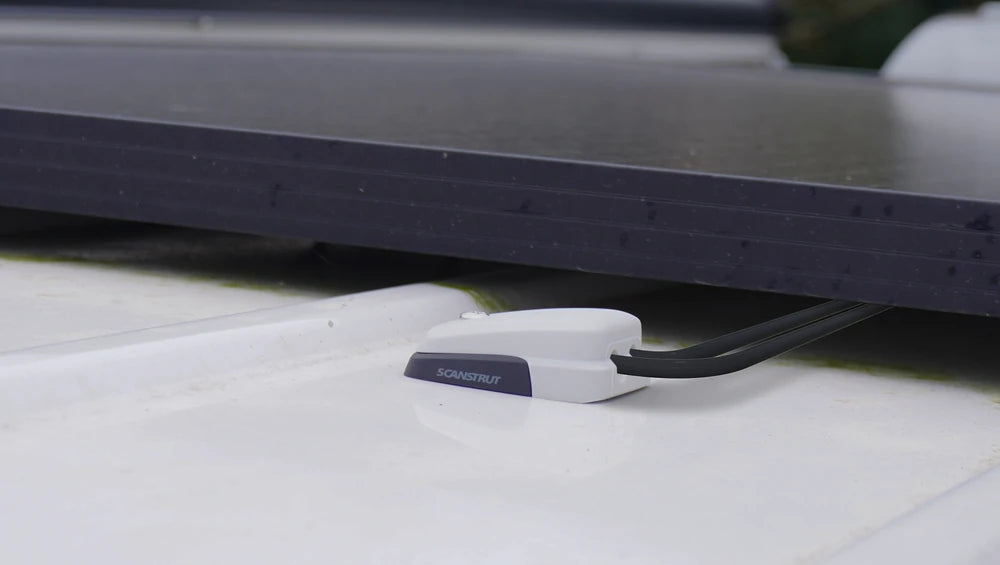 Low profile grey cable seal installed on a textured white roof surface