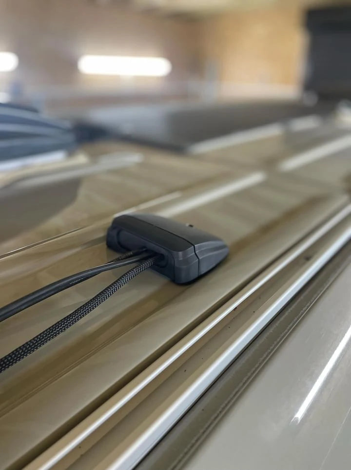 Side view of a horizontal multi cable seal mounted on a ribbed vehicle roof