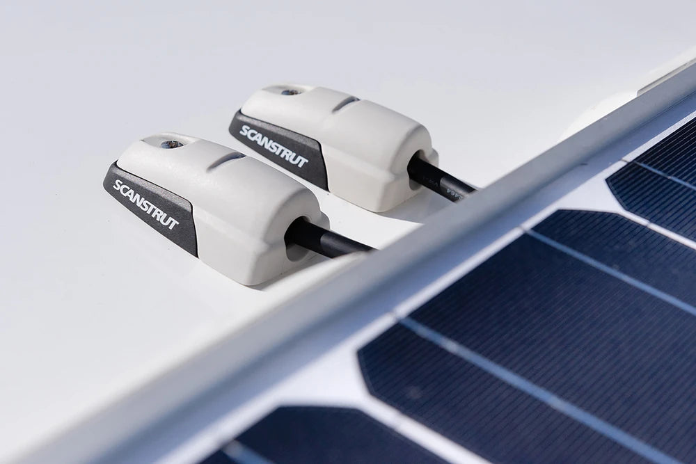 Two horizontal cable seals managing solar panel wiring on a roof