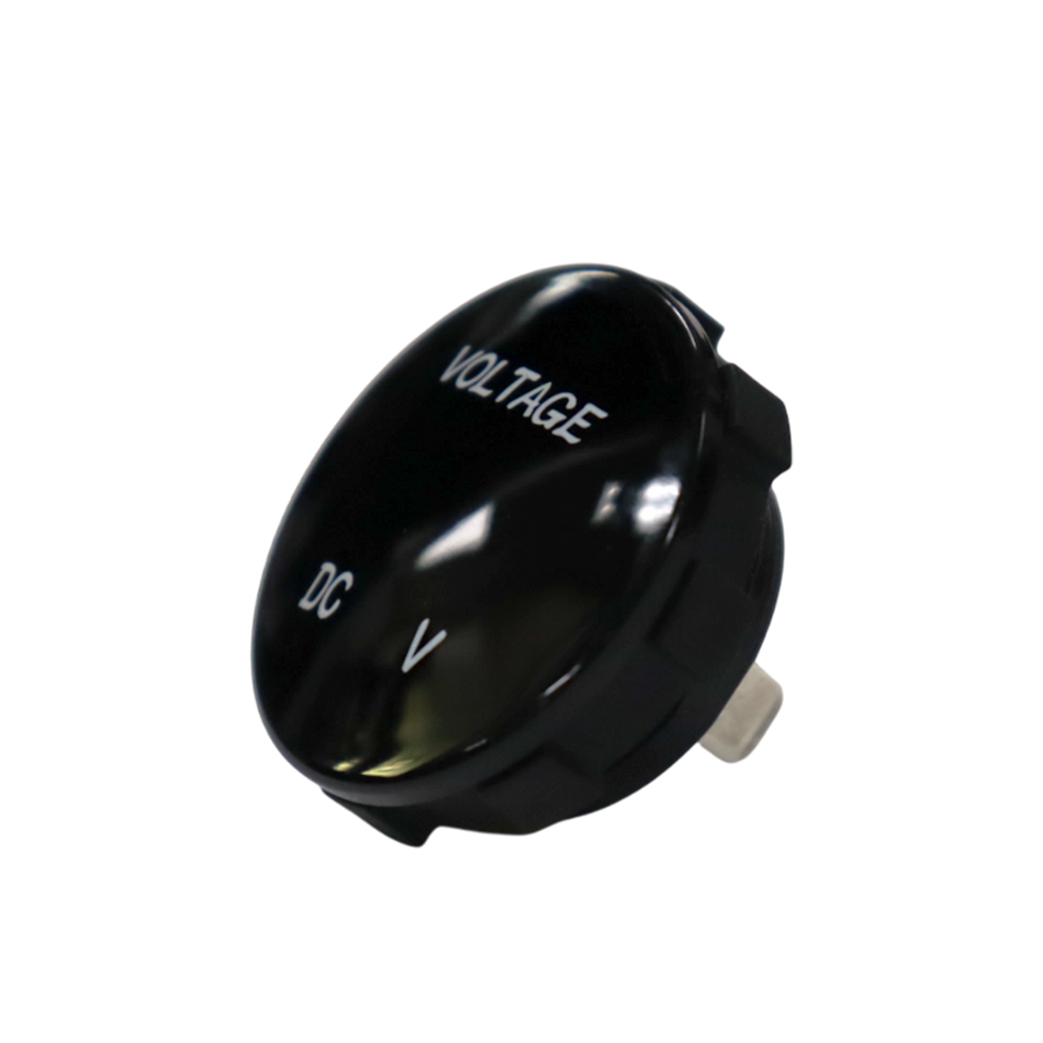Angled front view of round black voltmeter gauge displaying VOLTAGE and DC V text