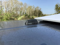 Waterproof cable seal with raindrops installed on a grey vehicle roof near a solar panel